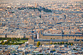 Aerial view of Paris, including the Louvre museum and Montmartre Cathedral.