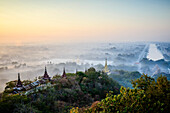 Erhöhter Blick auf die Ebene der Tempel in Mandalay, Stupas und Türme, die aus dem Nebel auftauchen, historische buddhistische Stätten, Myanmar