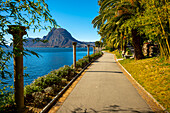 Walkway with Column on Lake Lugano with Mountain Peak Monte Bre and a Palm Tree in a Sunny Day with Clear Sky in Lugano, Ticino, Switzerland.
