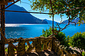 Balkon am Luganersee mit Berg und Baum an einem sonnigen Tag mit klarem Himmel in Lugano, Tessin, Schweiz.