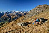Man and woman hiking taking a break, Lasörling in the background, Virgental, Hohe Tauern, Hohe Tauern National Park, East Tyrol, Austria