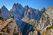 Woman hiking sitting on observation tower, Cadini Group in the background, on Monte Campedelle, Three Peaks, Dolomites, UNESCO World Natural Heritage Dolomites, Venetia, Venetia, Italy