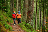 Man and woman hiking through forest, Ellbachsee, Black Forest National Park, Black Forest, Baden-Württemberg, Germany