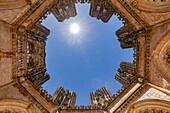 Sonnenstern im Gegenlicht über den prachtvollen unvollendeten Kapellen vom Kloster Batalha mit Ultraweitwinkel, Portugal