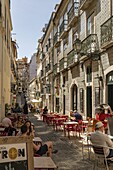 A street lined with cafes and outside seating in Lisbon, Portugal