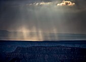 Storm clouds pass over the Grand Canyon and produce sunbeams near Timp Point,Kaibab National Forest,Arizona.