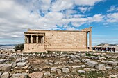 Many tourists visiting ancient Erechtheion,portico of the Caryatids - a miracle in Athens,Greece.