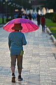 Local woman holding an umbrella to repair from the sun in Phnom Penh,Cambodia,South east Asia.