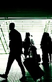 Silhouettes of people at an airport.