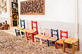 Typische bunte handgefertigte Stühle vor einem Geschäft mit lokalem Kunsthandwerk, Estremoz, Alentejo, Portugal.