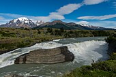 View of the Paine River waterfall with Admiral Nieto Mountain (left) and the Torres del Paine (Towers of Paine) in Torres del Paine National Park in southern Chile.
