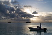 Sonnenuntergang mit kleinen Booten. Strand Fernandez Bay Village, Cat Island. Bahamas.