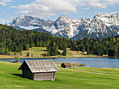 The Karwendel Mountain Range near Mittenwald during spring, lake Wagenbruch (also called Geroldsee). The green pasture is in a strong contrast with the still snow covered peaks of the western Karwendel mountains towering above Mittenwald. Bavaria