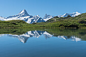 Schreckhorn and surrounding peaks reflect in the calm waters of Bachalpsee, above Grindewald in the Bernese Oberland region of Switzerland.