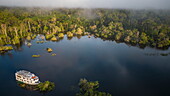 Luftaufnahme des Flussschiff MV Dorinha (ein traditioneller Amazonas-Dampfer), das an überflutete Bäume in der Flusslandschaft gebunden ist, nahe Manaus, Amazonas, Brasilien, Südamerika