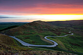 Sonnenuntergang am Rushup Edge mit kurvenreicher Straße nach Edale, Peak District, Derbyshire, England, Vereinigtes Königreich, Europa