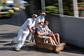 Tourists travelling down the toboggan basket ride, Madeira, Portugal, Atlantic, Europe