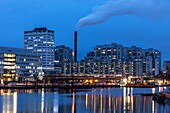 Modernes Viertel von Merihaka mit dem Schornstein des Hanasaari-Elektrizitätswerks bei Einbruch der Dunkelheit, Helsinki, Finnland, Europa