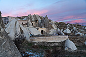 Turkey, Cappadocia, Goreme, Cave dwellings in fairy chimneys at dusk