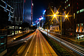 Exterior view of modern cityscape with long exposure of vehicles moving on street in Hong Kong