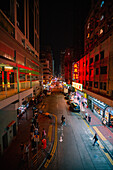 City street with local market stalls at night in Hong Kong