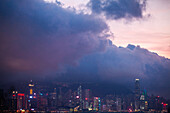 View of illuminated cityscape with skyscraper near Victoria Harbour in Hong Kong