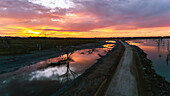 View of dirt road passing through coastline during sunset against cloudy sky, Villa Epecuen