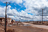 Ansicht der unbefestigten Straße, die durch verlassenes Dorf gegen bewölkten Himmel, Villa Epecuen führt