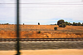 Blick auf trockene Landschaft durch Zugfenster, Spanien
