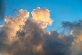 Goldene und graue Kumuluswolken am Himmel bei Sonnenuntergang