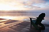USA, New York, Lake Placid, Adirondack Chair am Pier  bei Sonnenaufgang