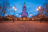 Polen, Masowien, Warschau, beleuchtetes Hochhaus am Stadtplatz