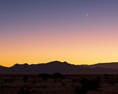 USA, New Mexico, Santa Fe, Crescent moon above Jemez Mountains at sunset