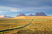 USA, Arizona, Empty road in desert leading to Monument Valley