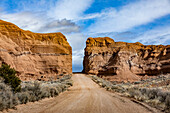 USA, Utah, Escalane, Dirt road between sandstone cliffs in Grand Staircase-Escalante National Monument