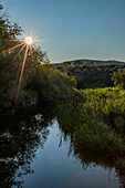 USA, Idaho, Bellevue, Morning sun over spring creek near Sun Valley