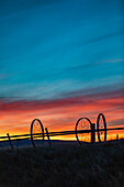 USA, Idaho, Bellevue, Silhouette von Bewässerungsrädern im Feld bei Sonnenuntergang