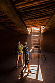 Boy (8-9) and girl (14-15) exploring Native American kiva in Pecos National Monument