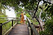 Africa, Northern Namibia, Mother and daughter (16-17) on wooden walkway in Nambwa River Lodge