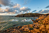 Killantringan Lighthouse auf Black Head und felsige Küste bei Sonnenuntergang, Portpatrick, Dumfries and Galloway, Schottland, Vereinigtes Königreich, Europa