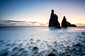 Langzeitbelichtung von Wellen, die in der Dämmerung auf die Felsformationen Ilheus da Rib und Ribeira da Janela krachen, Insel Madeira, Portugal, Atlantik, Europa