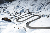 Auto unterwegs auf Kurven der kurvenreichen Straße im Schnee, Julierpass, Bezirk Albula, Engadin, Kanton Graubünden, Schweiz, Europa