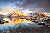 Dramatic sky at dawn over Mount Olstind covered with snow, Reine Bay, Nordland, Lofoten Islands, Norway, Scandinavia, Europe