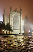 Eine atmosphärische, neblige Winteransicht des Ostfensters von York Minster nach Einbruch der Dunkelheit, York, Yorkshire, England, Vereinigtes Königreich, Europa