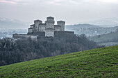 Mittelalterliche Burg von Torrechiara mit quadratischen Türmen auf einem Hügel an einem nebligen Tag, Torrechiara, Emilia Romagna, Italien, Europa