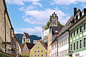 Old town of Füssen with houses on Reichenstrasse and a view of the Hohes Schloss and St. Mang Monastery in Oestallgäu in Bavaria in Germany