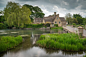 Pretty mill house on the banks of the River Coln in spring in the Cotswolds village of Fairford, Gloucestershire, England, United Kingdom, Europe