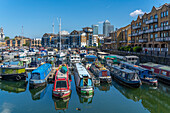 View of canal boats in the marina at the Limehouse Basin and Canary Wharf in background, Limehouse, London, England, United Kingdom, Europe
