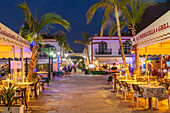 Blick auf Cafés und Restaurants in Puerto de Mogan und bergigen Hintergrund in der Abenddämmerung, Puerto de Mogan, Gran Canaria, Kanarische Inseln, Spanien, Atlantik, Europa