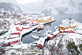 Hochwinkelansicht der traditionellen Fischerhütten und des schneebedeckten Hafens, Nusfjord, Nordland, Lofoten, Norwegen, Skandinavien, Europa